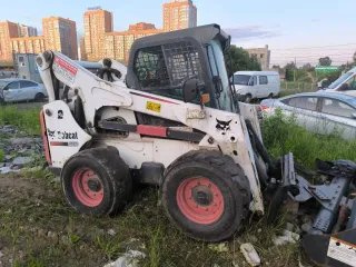 Мини-погрузчик Bobcat S850 заводской номер ACSL11164 Навесное оборудование щетка с бункером Sweeper Bucket 84 серийный номер А00А01354 снегоуборочный отвал V-Blade 84 серийный номер 084001021 угловая метла Angle Broom 84 серийный номер 231416282