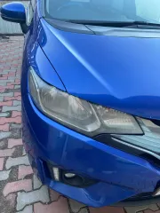 Honda Fit 2013 года выпуска, VIN кузова GK31020913 (GK3-1020913). Автомобиль после ДТП: глубокие вмятины и деформация левой передней двери (требуется замена), вмятины и царапины левой задней двери (требуется ремонт и покраска), вмятины порога с левой стороны. Царапины и сколы краски по всему…