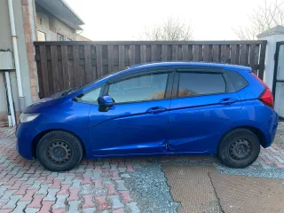 Honda Fit 2013 года выпуска, VIN кузова GK31020913 (GK3-1020913). Автомобиль после ДТП: глубокие вмятины и деформация левой передней двери (требуется замена), вмятины и царапины левой задней двери (требуется ремонт и покраска), вмятины порога с левой стороны. Царапины и сколы краски по всему…