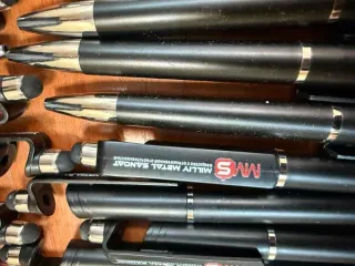 Канцелярские принадлежности и бумажная продукция MMS: картонные папки белого цвета с фирменным логотипом "MMS MILLIY METAL SANOAT" - 41шт, ручки черного цвета с фирменным логотипом "MMS MILLIY METAL SANOAT" - 49шт, блокнот с фирменным логотипом "MMS MILLIY METAL SANOAT" - 50шт, коврик черного цвета…