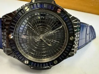 Hublot Big Bang Tutti Frutti Dark Blue Caviar 346.CD.1800.LR.1901 наручные часы в круглом корпусе из металла темного цвета со вставками синего цвета. Часы имеют ремешок из материала синего цвета с замком из металла черного цвета. На оборотной стороне часов имеется надпись «HUBLOT», «BIG BANG»…