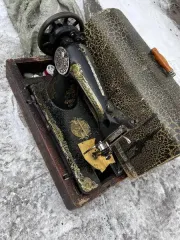 Швейная машина с ручным приводом в деревянном футляре, созданная менее 100 лет назад.