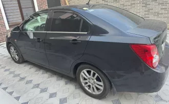 Шевроле KL1T (Aveo) 2014 года выпуска. VIN: XUFTA69EJEN024329. Цвет кузова: черный металлик. Объем двигателя: 1598 см³, мощность: 116 л.с. Экологический класс: 4. Тип: легковой седан. Пробег: 149 054 км. Транспортное средство находится в залоге ПАО «Совкомбанк».