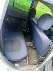 Mazda Demio 2003 года, 91 лс. Цвет белый. Госномер Р144АК142. Кузов DY3W-231087, имеются вмятины и коррозийные повреждения на багажнике.