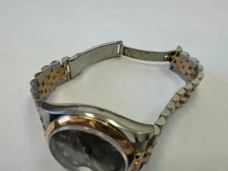 Наручные часы «Rolex Datejust ref. 116203» (на часах указан идентификационный номер «S7776635») ,корпус круглый, из металла серебристого цвета со вставкой из металла золотистого цвета и прозрачными камнями на циферблате, браслет из металла серебристого цвета с золотистой вставкой в центре и с…