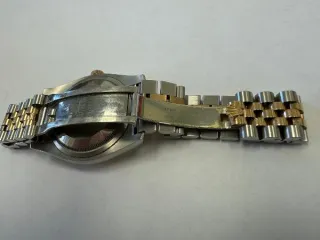 Наручные часы «Rolex Datejust ref. 116203» (на часах указан идентификационный номер «S7776635») ,корпус круглый, из металла серебристого цвета со вставкой из металла золотистого цвета и прозрачными камнями на циферблате, браслет из металла серебристого цвета с золотистой вставкой в центре и с…