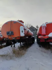 Нефаз 96742-03 2010 года, полуприцеп-цистерна оранжевого цвета. VIN: X1F96742BA0001118, госномер: АР584786. Имеет множественные сколы, местами коррозию, отсутствуют все колесные диски и резина.