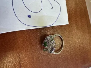 Кольцо Chaumet 750 пробы с камнями, 56 размер. Кольцо из белого металла, выполненное в виде сложной геометрической фигуры, на поверхности которой имеются вставки из камней. На поверхности кольца имеются штампованные надписи «CHAUMET», «750», «56», «1043233».