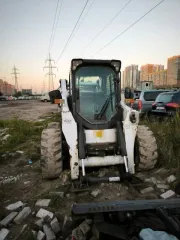 Мини-погрузчик Bobcat S850 заводской номер ACSL11164 Навесное оборудование щетка с бункером Sweeper Bucket 84 серийный номер А00А01354 снегоуборочный отвал V-Blade 84 серийный номер 084001021 угловая метла Angle Broom 84 серийный номер 231416282