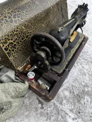 Швейная машина с ручным приводом в деревянном футляре, созданная менее 100 лет назад.