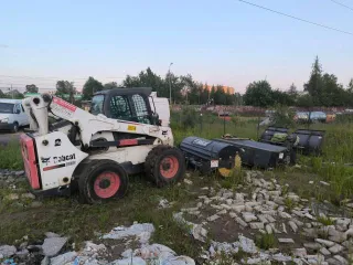 Мини-погрузчик Bobcat S850 заводской номер ACSL11164 Навесное оборудование щетка с бункером Sweeper Bucket 84 серийный номер А00А01354 снегоуборочный отвал V-Blade 84 серийный номер 084001021 угловая метла Angle Broom 84 серийный номер 231416282