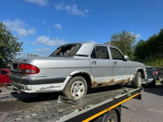 ГАЗ-3110 2002 года, годные остатки. Стального цвета, VIN: XTH31100021108667. Многочисленные трещины и сколы на переднем и заднем бампере. Отсутствует решетка радиатора с левой стороны. Глубокая коррозия металла, в том числе сквозная, многочисленные вмятины, следы ржавчины по всему кузову. Трещины…