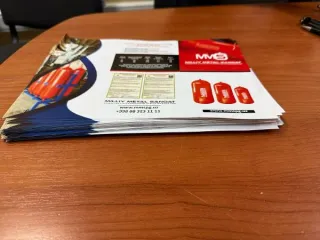 Канцелярские принадлежности и бумажная продукция MMS: картонные папки белого цвета с фирменным логотипом "MMS MILLIY METAL SANOAT" - 41шт, ручки черного цвета с фирменным логотипом "MMS MILLIY METAL SANOAT" - 49шт, блокнот с фирменным логотипом "MMS MILLIY METAL SANOAT" - 50шт, коврик черного цвета…