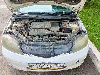 Mazda Demio 2003 года, 91 лс. Цвет белый. Госномер Р144АК142. Кузов DY3W-231087, имеются вмятины и коррозийные повреждения на багажнике.