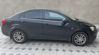 Шевроле KL1T (Aveo) 2014 года выпуска. VIN: XUFTA69EJEN024329. Цвет кузова: черный металлик. Объем двигателя: 1598 см³, мощность: 116 л.с. Экологический класс: 4. Тип: легковой седан. Пробег: 149 054 км. Транспортное средство находится в залоге ПАО «Совкомбанк».