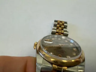 Наручные часы «Rolex Datejust ref. 116203» (на часах указан идентификационный номер «S7776635») ,корпус круглый, из металла серебристого цвета со вставкой из металла золотистого цвета и прозрачными камнями на циферблате, браслет из металла серебристого цвета с золотистой вставкой в центре и с…