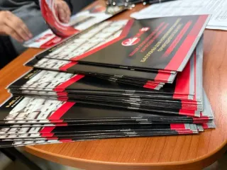 Канцелярские принадлежности и бумажная продукция MMS: картонные папки белого цвета с фирменным логотипом "MMS MILLIY METAL SANOAT" - 41шт, ручки черного цвета с фирменным логотипом "MMS MILLIY METAL SANOAT" - 49шт, блокнот с фирменным логотипом "MMS MILLIY METAL SANOAT" - 50шт, коврик черного цвета…