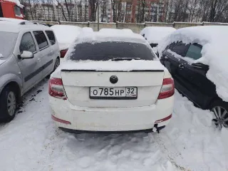 Skoda Octavia 2013 года выпуска, VIN XW8AC4NE8EH016970. Цвет белый, госномер О785НР32. Автомобиль в залоге. Не на ходу: не работает коробка передач, двигатель заводится. Состояние кузова требует покраски, имеются повреждения стоп-сигналов, множество сколов и царапин.